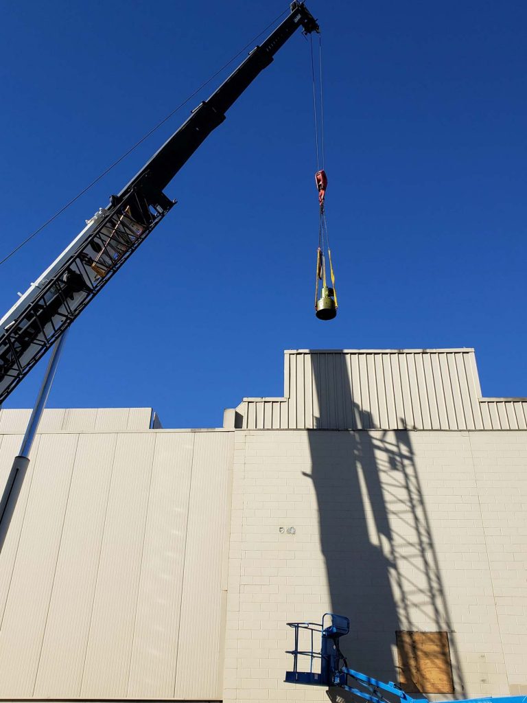 A crane listing a piece of equipment - Where to find rigging services in Marine City, MI
