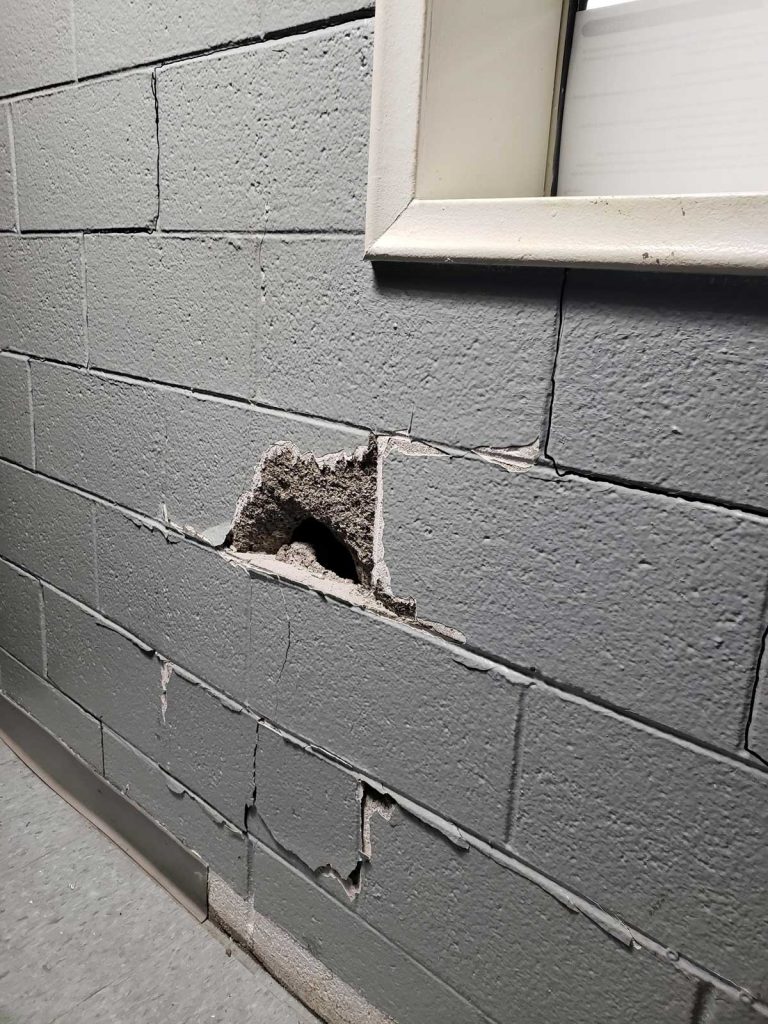 concrete wall with hole that needs to be patched